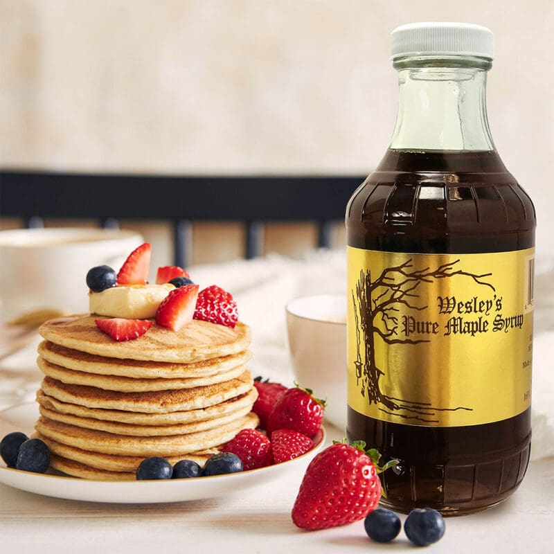 71050 Wesley’s 16oz Maple Syrup Wesley's 16oz Maple Syrup in use on a breakfast table with pancakes
