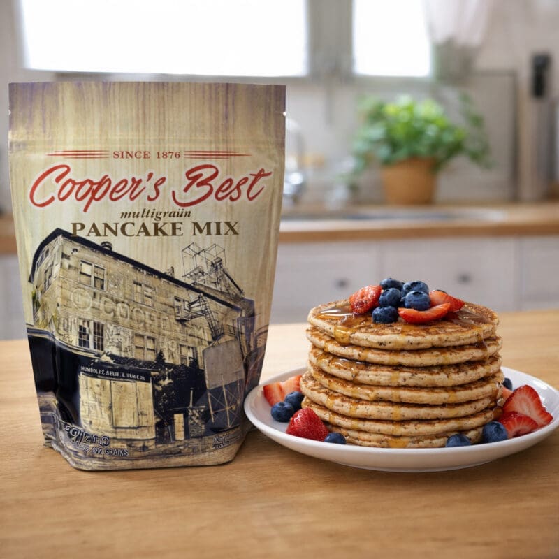 Cooper's Best Multigrain Pancake Mix next to freshly made Multigrain Pancakes