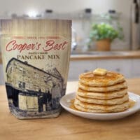 Cooper's Best Buttermilk Pancake Mix next to freshly made Buttermilk Pancakes