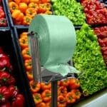 100% Recycled Produce Bags Pull N Pak shown on a rack in front of produce