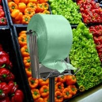 100% Recycled Produce Bags Pull N Pak shown on a rack in front of produce