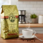 Pear's Coffee Jamaica Me Nuts 24oz next to a cup of coffee