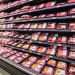 Supermarket meat case featuring ground beef and chicken with Family Pack Labels