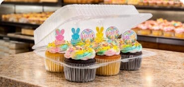 a cupcake disposable take out container on a bakery countertop
