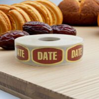 date label on a gold foil stickers shown with several date fruits